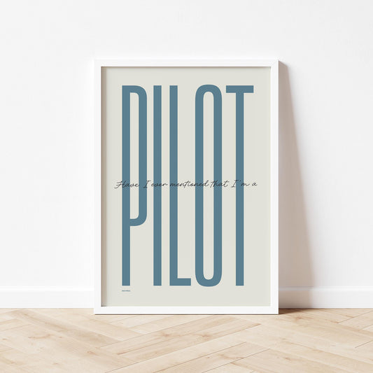 Framed poster standing on wood flooring, leaning against a white wall. It shows the words - have I ever mentioned that I'm a - in black handwritten style and the word - pilot - in large blue letters