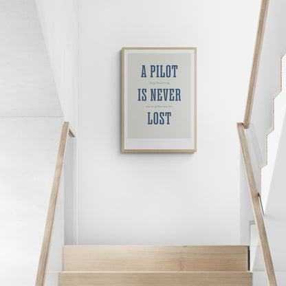 A framed print hanging in a staircase landing. It shows the words - A Pilot Is Never Lost - in large blue letters and the words - Only temporarily unsure of their position - in in black handwritten style