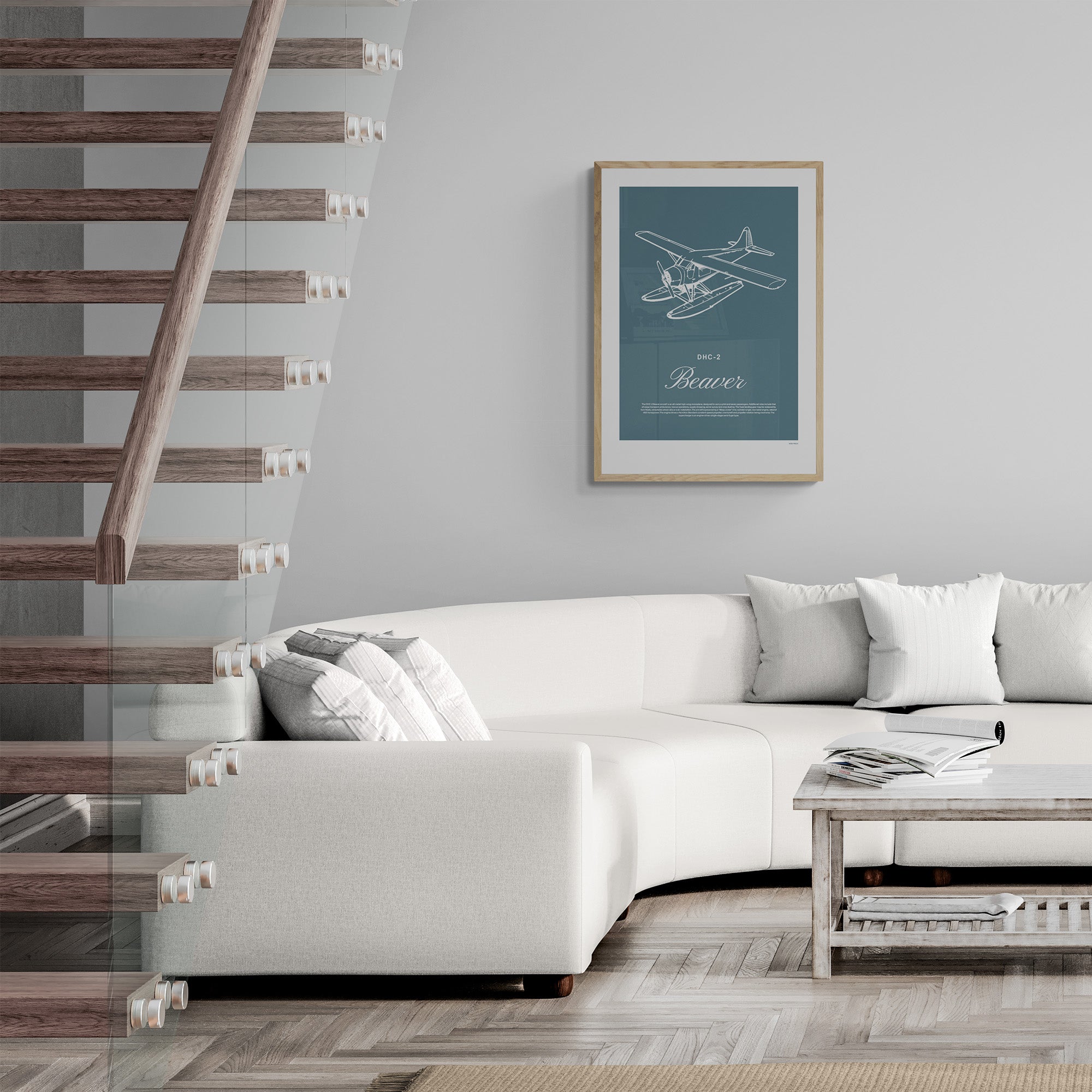 A framed print hanging in a modern living room, over a white sofa and next to a glass and wood staircase. It shows a light aircraft illustration with the words DHC-2 Beaver in white over a teal background