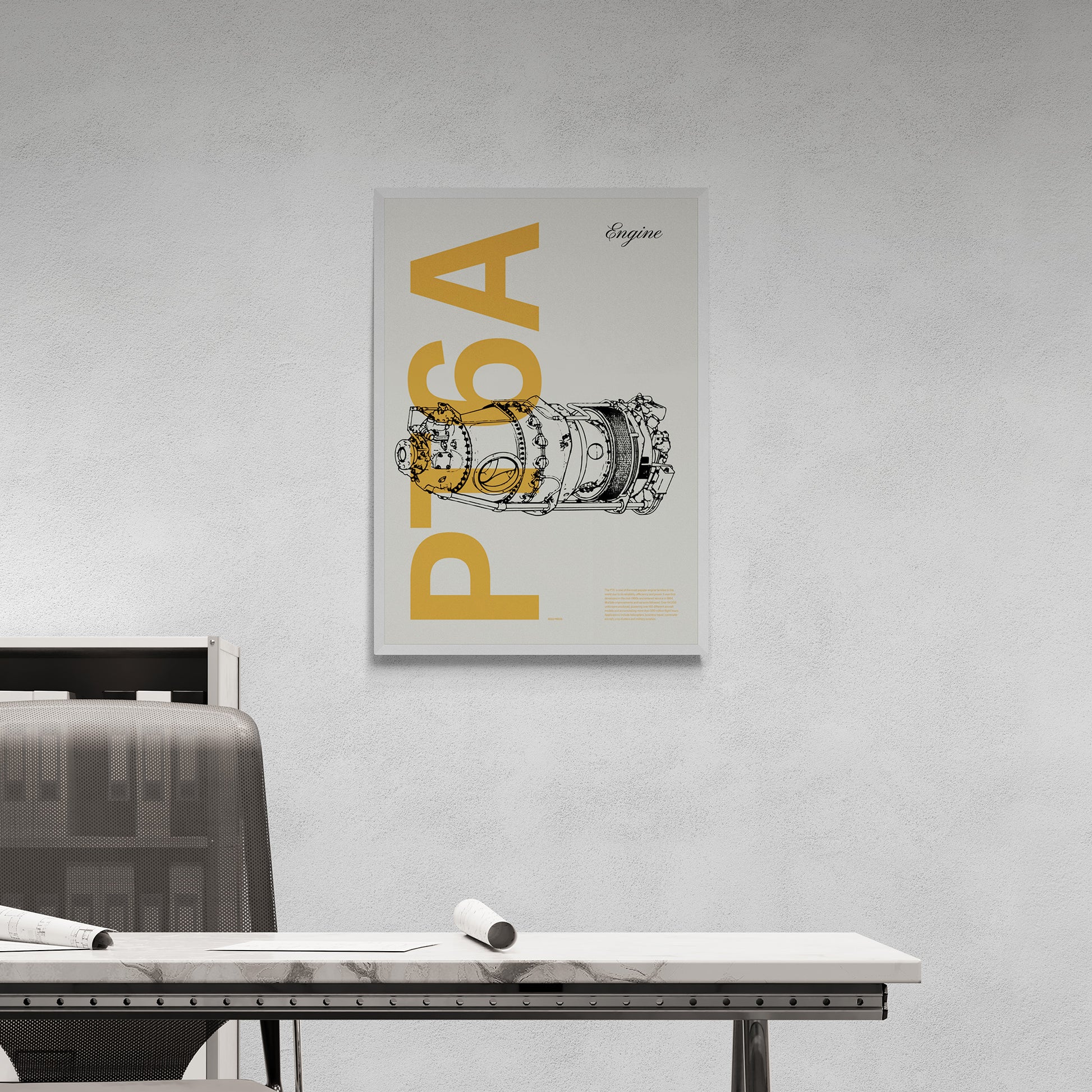 Framed poster hanging in an office over a desk and next to a chair. It shows a PT6A aircraft engine in line drawing style with the word PT6A written big in mustard yellow