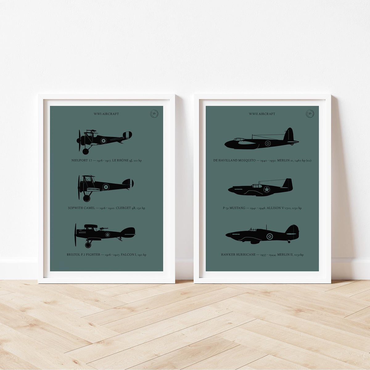 Two framed posters standing on wood flooring, leaning against a white wall. Each shows the profiles of 3 historic aeroplanes in a black silhouette style over a dark green background 
