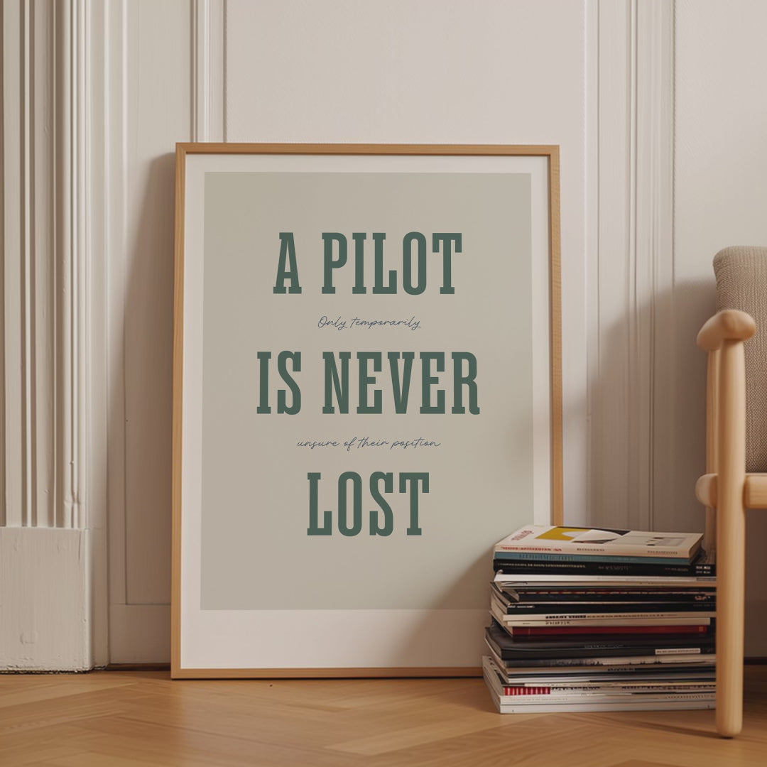 Framed poster displayed in variety of scenes. The poster shows the words - A Pilot Is Never Lost - in large green letters and the words - Only temporarily unsure of their position - in in black handwritten style