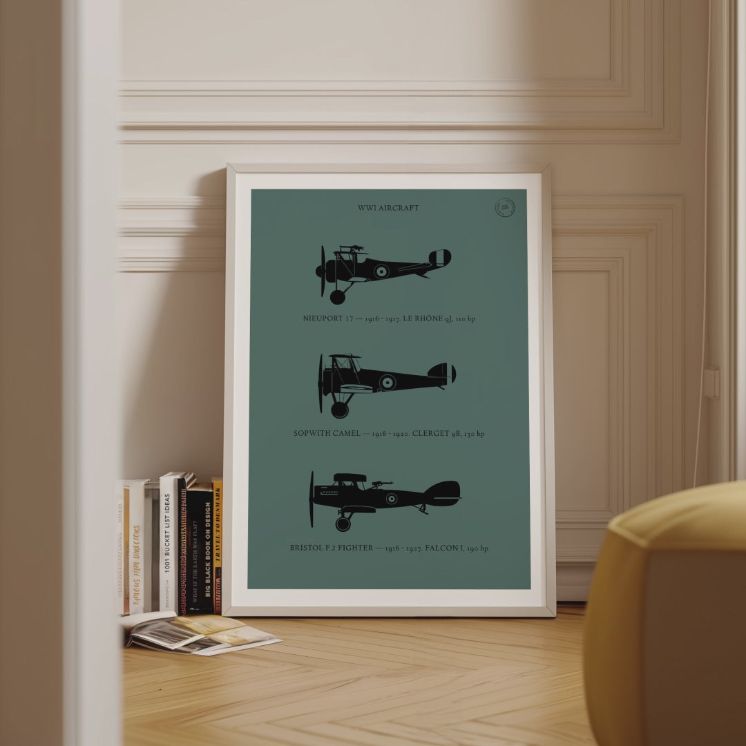 Framed poster displayed in variety of scenes. The poster shows the profiles of three WW1 period aeroplanes in a black silhouette style over a dark green background 