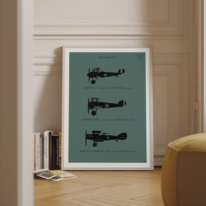 Framed poster displayed in variety of scenes. The poster shows the profiles of three WW1 period aeroplanes in a black silhouette style over a dark green background 