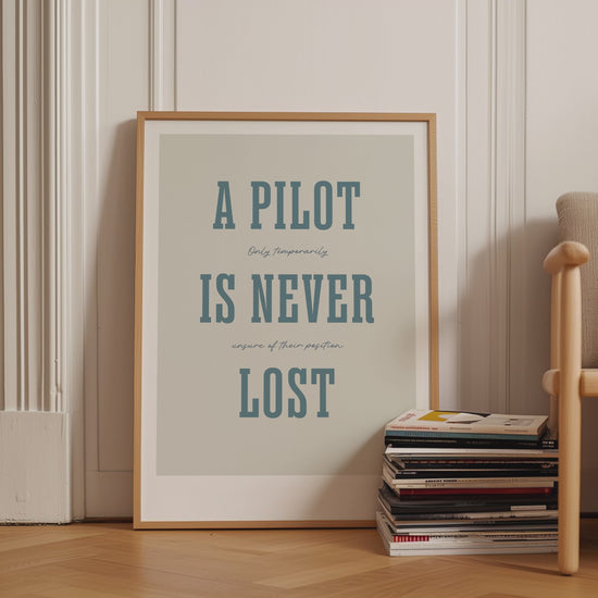 Framed poster displayed in variety of scenes. The poster shows the words - A Pilot Is Never Lost - in large blue letters and the words - Only temporarily unsure of their position - in in black handwritten styl