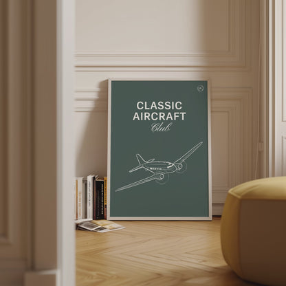 Framed poster displayed in variety of scenes. The poster shows a white illustration of a vintage aircraft in a dark green background with the words Classic Aircraft Club